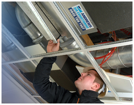 Andrews Air conditioning engineer looking into ceiling system Andrews Air conditioning engineer looking into ceiling system